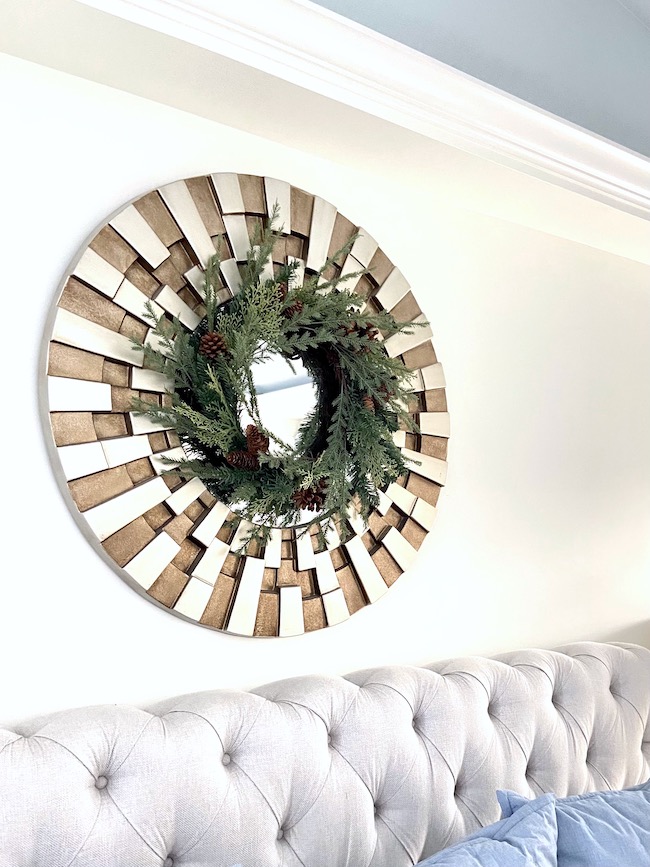 Wreath on mirror over bed