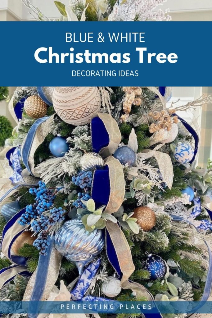 Blue and white Christmas tree decorated with navy velvet ribbon, gold ribbon, blue and white ornaments, and flocked greenery.