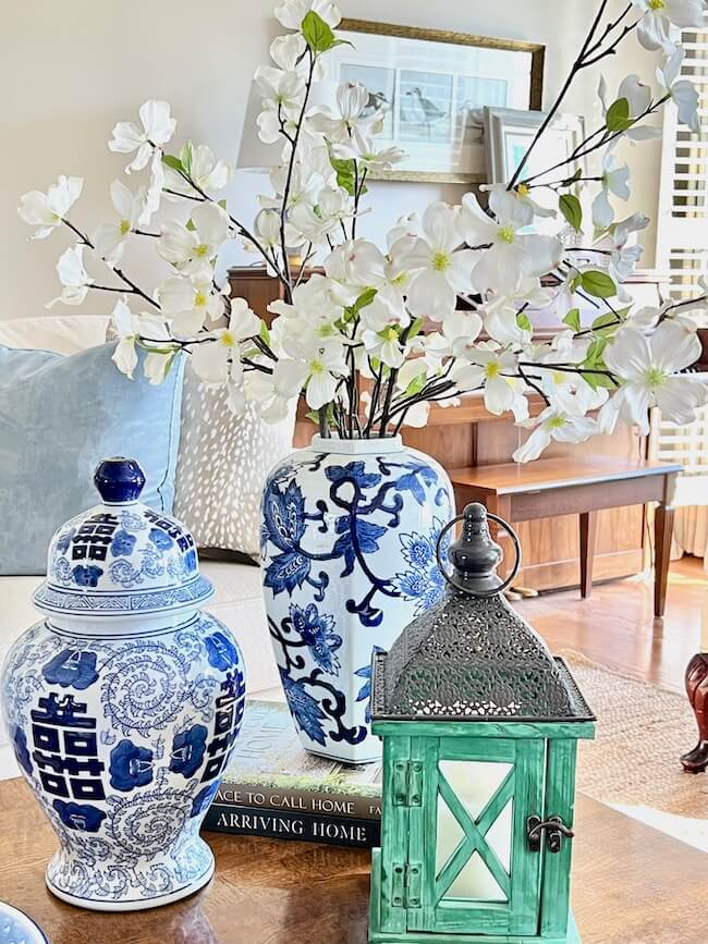 Spring Coffee table decor with faux dogwood stems and blue and white ginger jars.