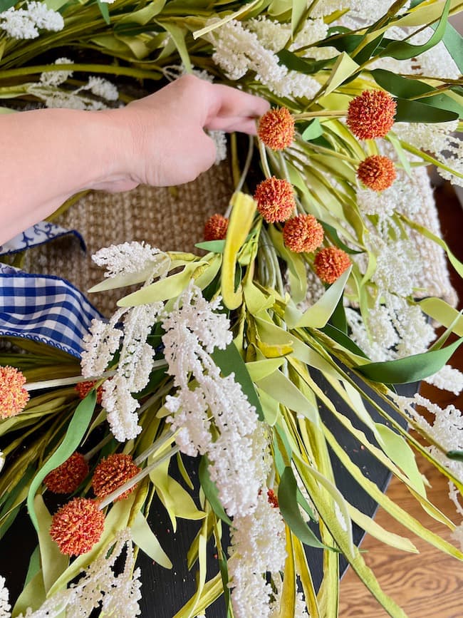 Add orange fall stems to the summer wreath.