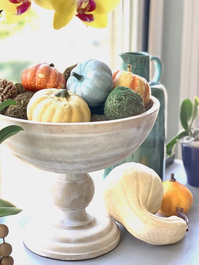 Pumpkins in a wooden pedestal bowl