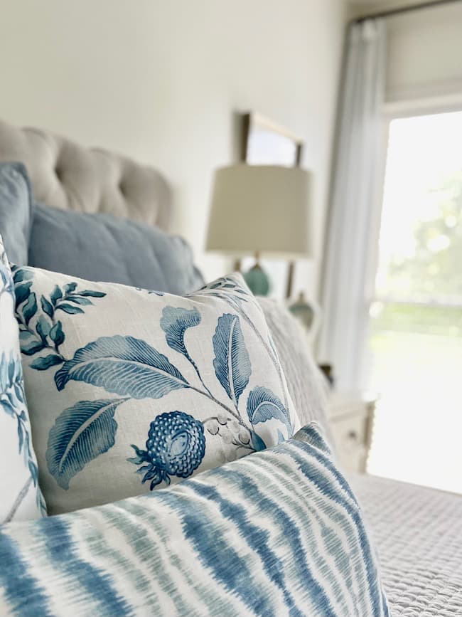 Layered Blue and white throw Pillows on bed
