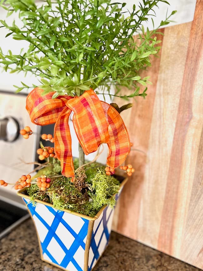 Blue white and orange fall rosemary topiary on counter