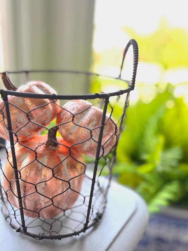 Decorating pumpkins for fall (Rose Gold Leaf Pumpkins in a metal basket)