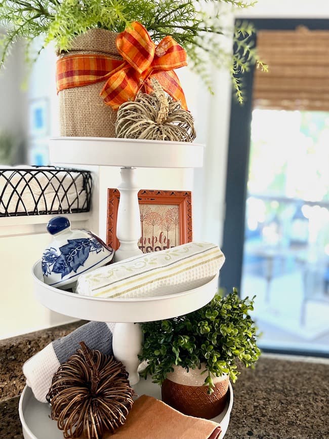 Three-tiered stand decorated for fall with blue and orange