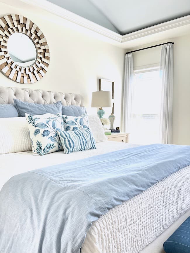 layered bedding on blue and white bed