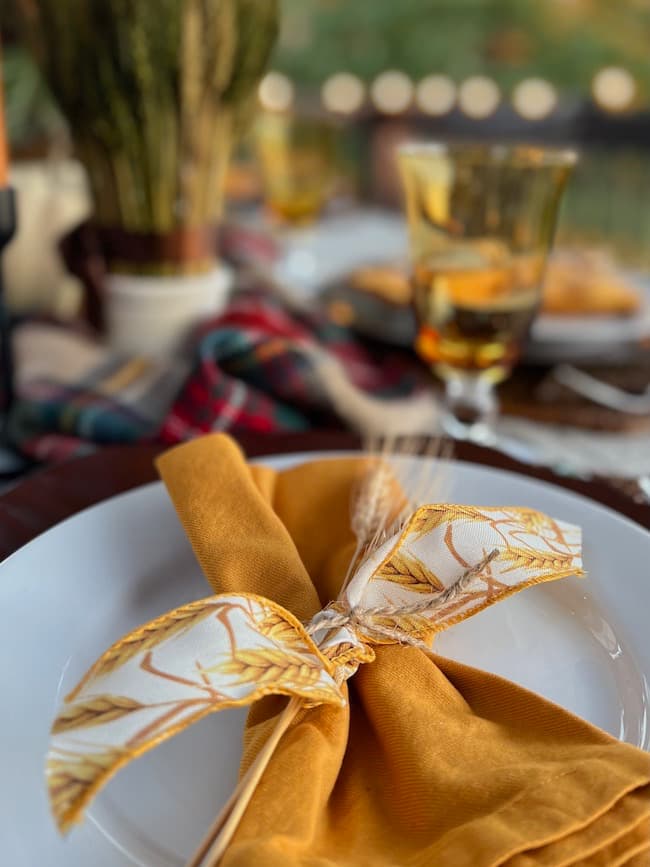 Gold napkins with wheat spray at table setting
