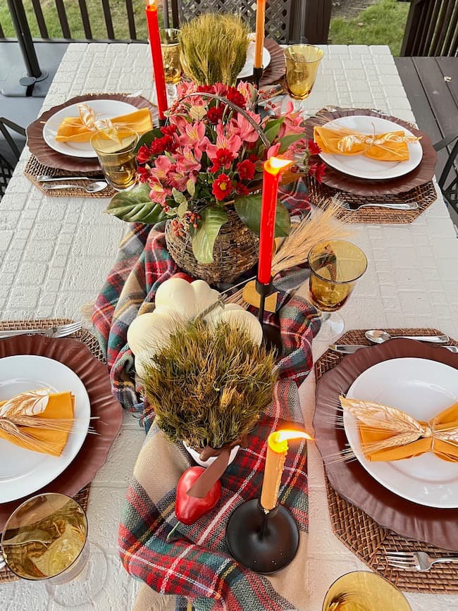 Thanksgiving table decor with plaid runner, white pumpkins, and candles