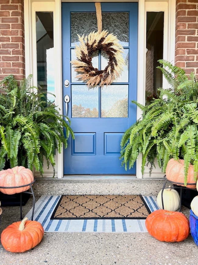 Fall porch with blue front door and DIY pinecone wreath