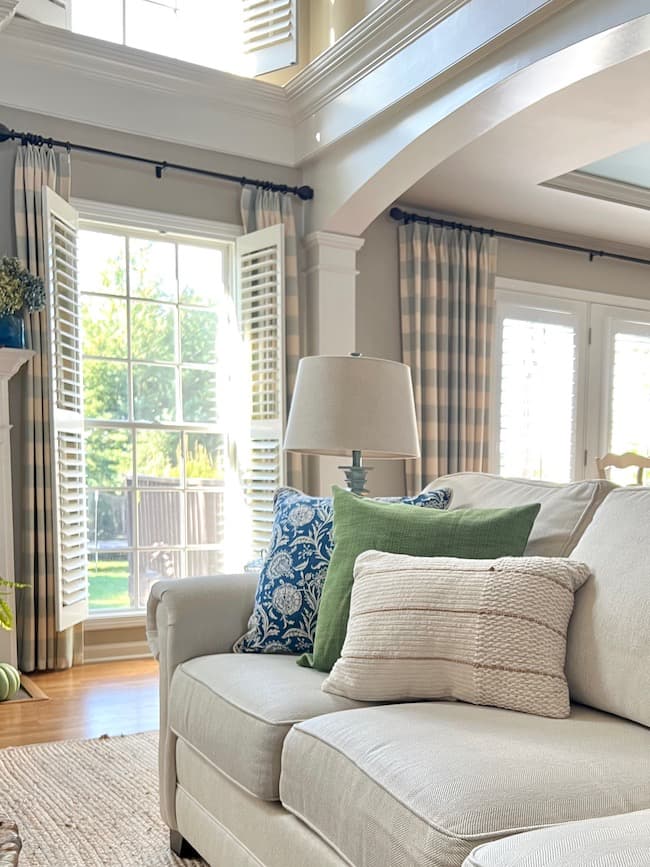 How to Choose Curtains for Living Room Windows   -- living room with blue and white buffalo check curtains.