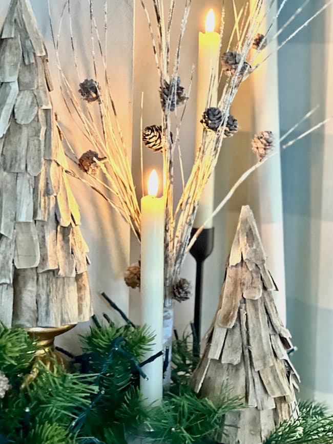 Wooden trees and pinecone sprays on the mantel for Christmas