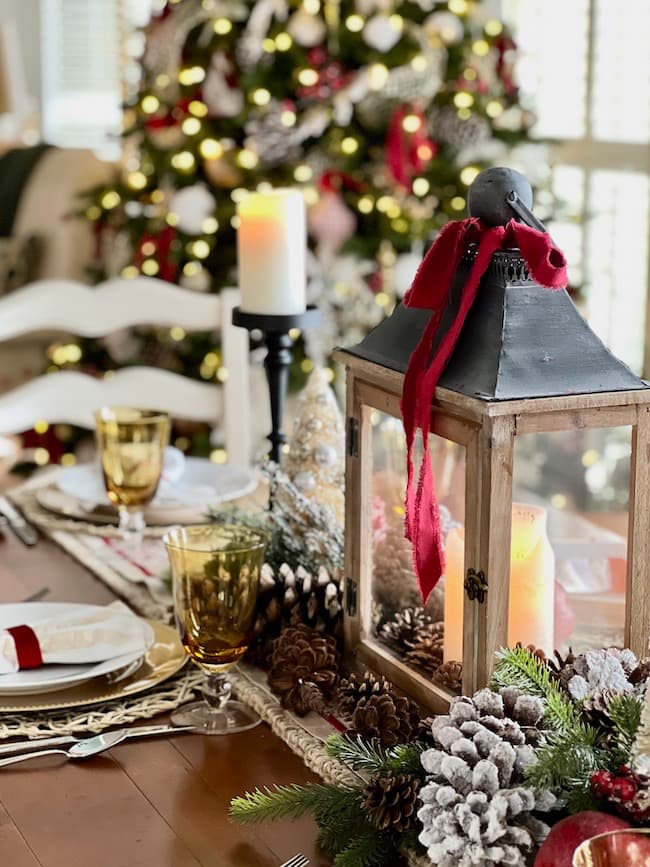 Christmas tablescape in the Dining table with lantern centerpiece and red velvet ribbon