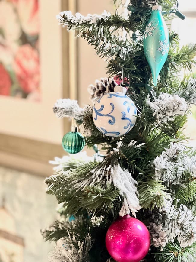 Hand painted blue and white Christmas ornament on tree with vintage ornaments