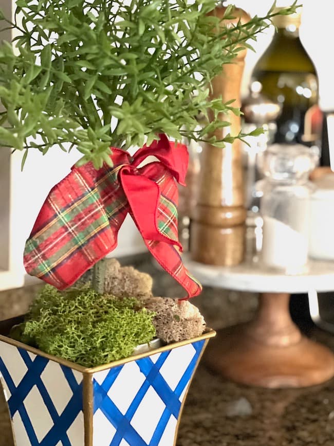 Add a bow to a topiary for Christmas