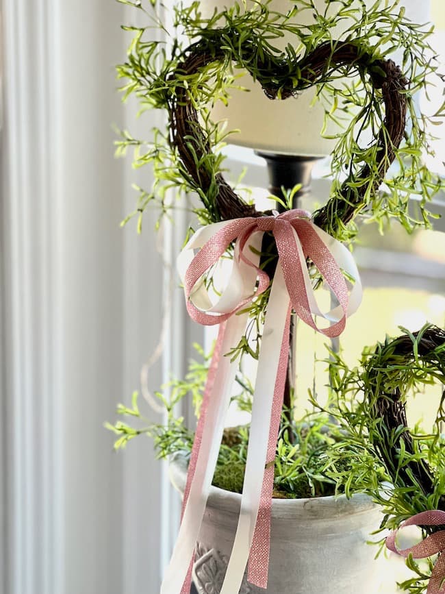 The DIy topiary with pink ribbon is in the kitchen window.