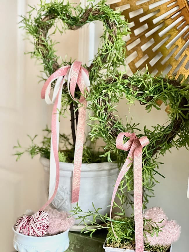 Make DIY heart shaped topiaries with pink bows.