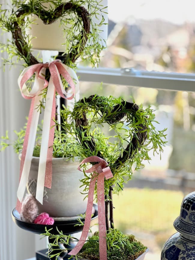 Valentine's Day heart topiaries with pink and white bows.