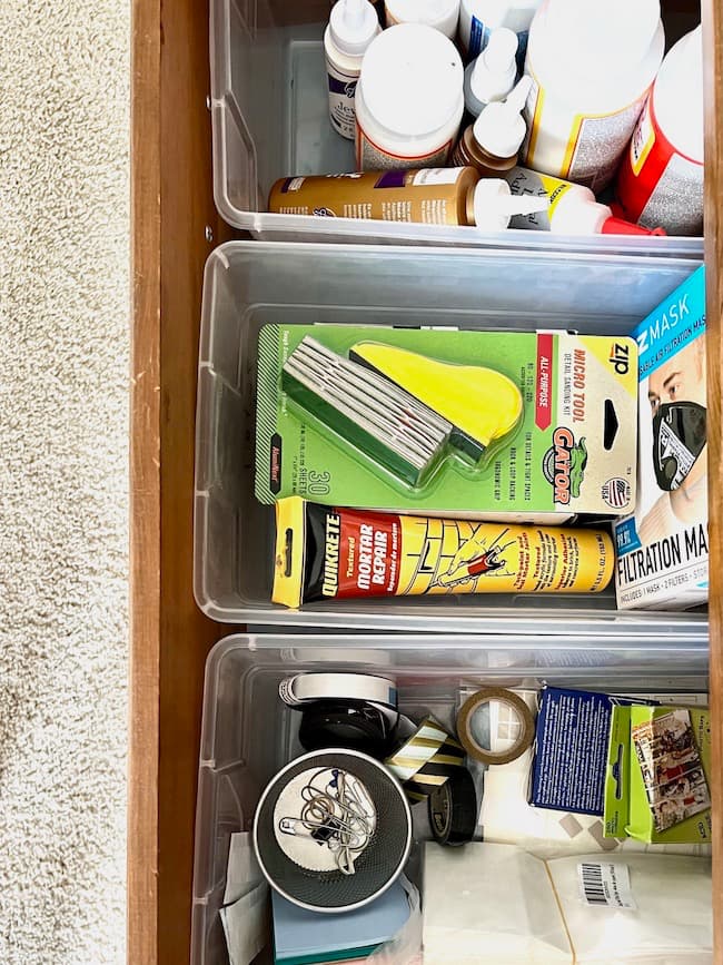 Plastic bins added to dresser drawers keep craft supplies organized.