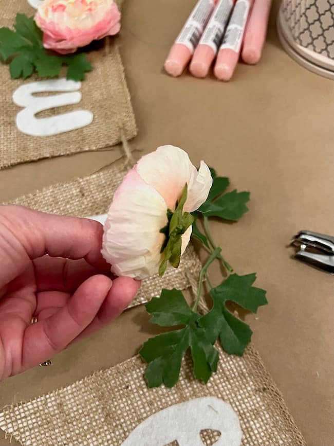 Hot glue the flowers to the banner.