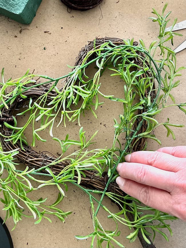 Add the greenery vines to the hearts.