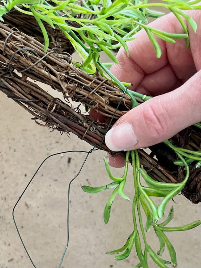 Attach the greenery to the grapevine hearts with florist wire.