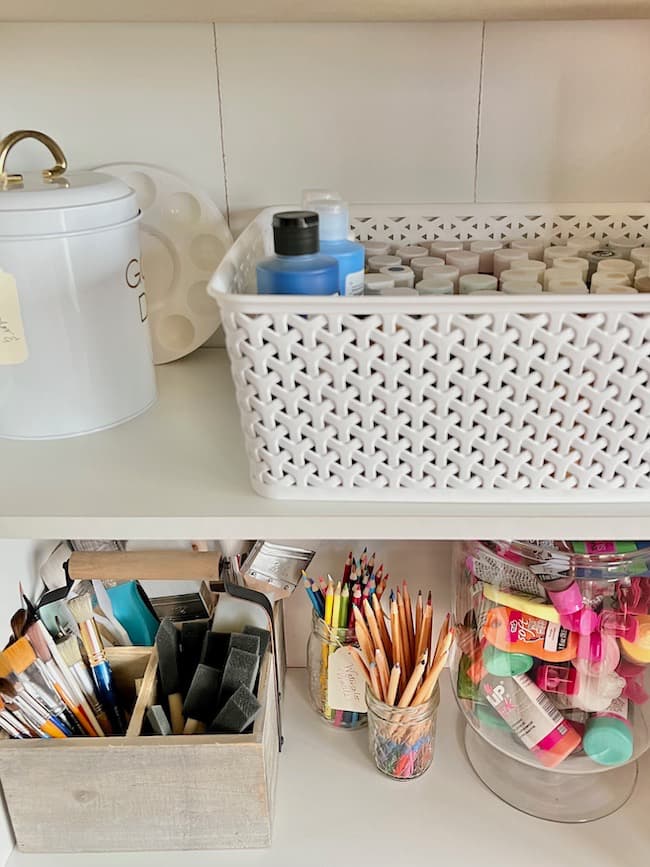 Organize  craft supplies by type like these paints and paintbrushes.