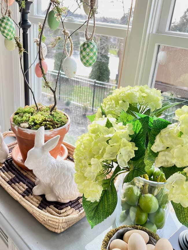 Kitchen buffet decorated for Easter with egg tree, hydrangeas, and ceramic bunnies