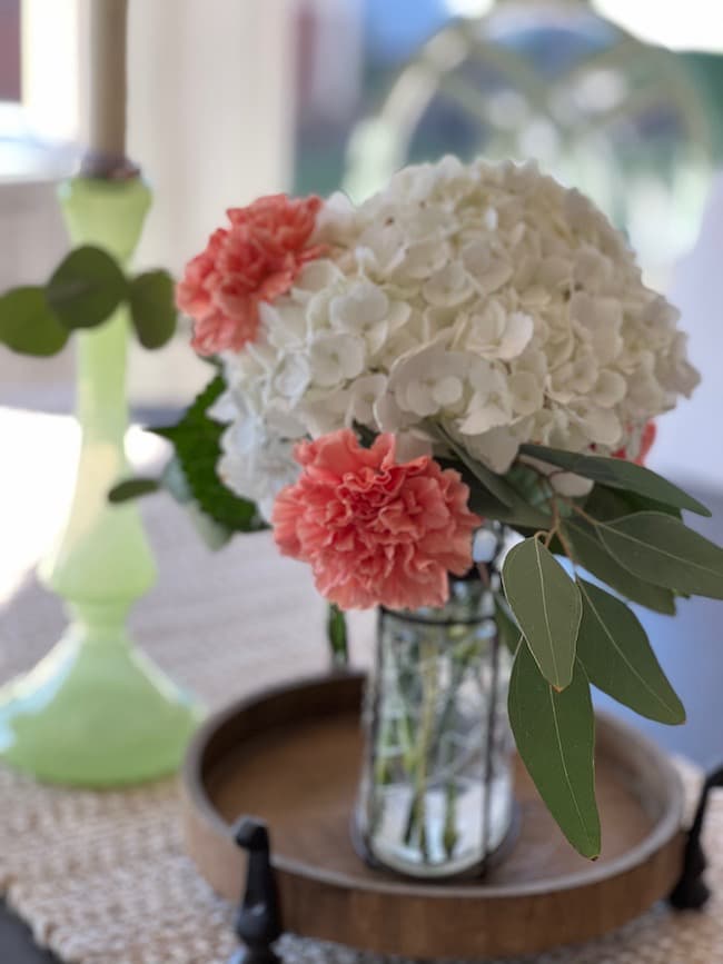Small spring flower arrangement with white hydrangeas and coral carnations