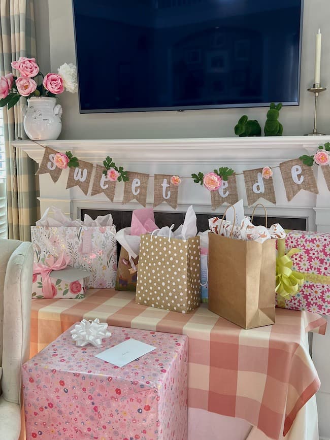 Garden theme baby shower gift table with pink and white buffalo plaid table cloth