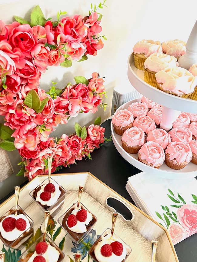 Garden theme baby shower dessert buffet with floral initial, trifles and flower cupcakes