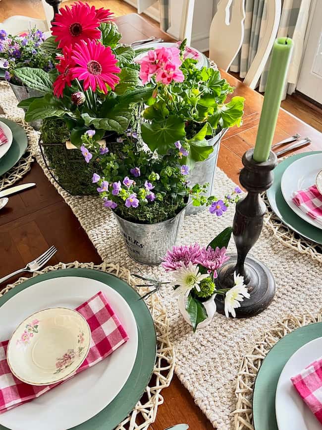 Place settings with green chargers, white plates, and pink and white plaid napkins