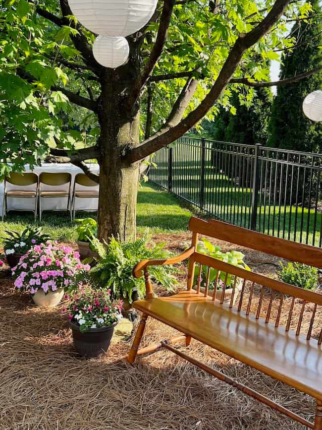 Garden photo area with bench for backyard engagement party.