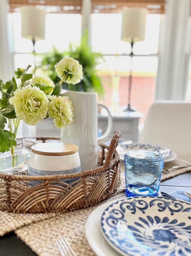 Centerpiece for round table with rattan tray and faux flower arrangement