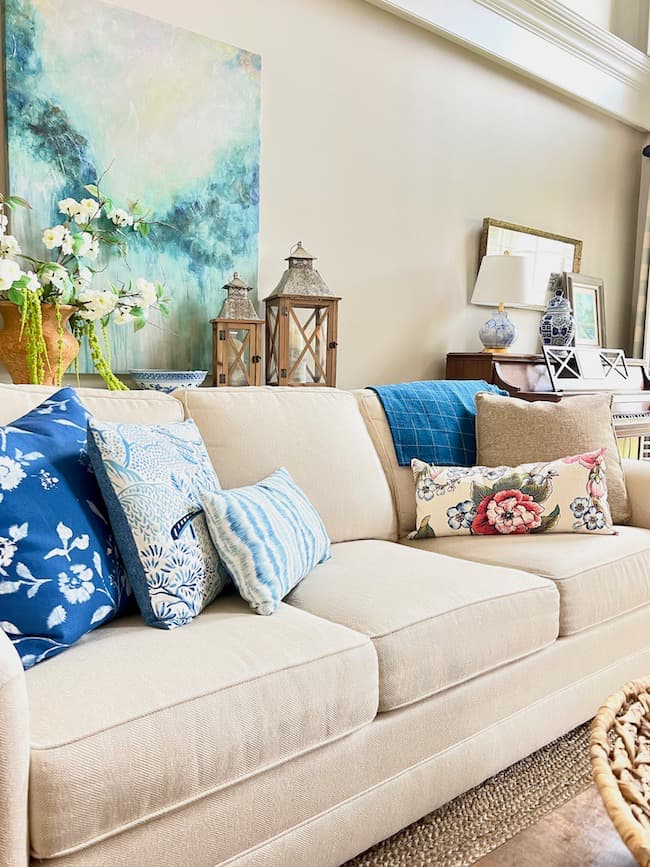 Living Room Sofa with blue and white throw pillows and coastal abstract art