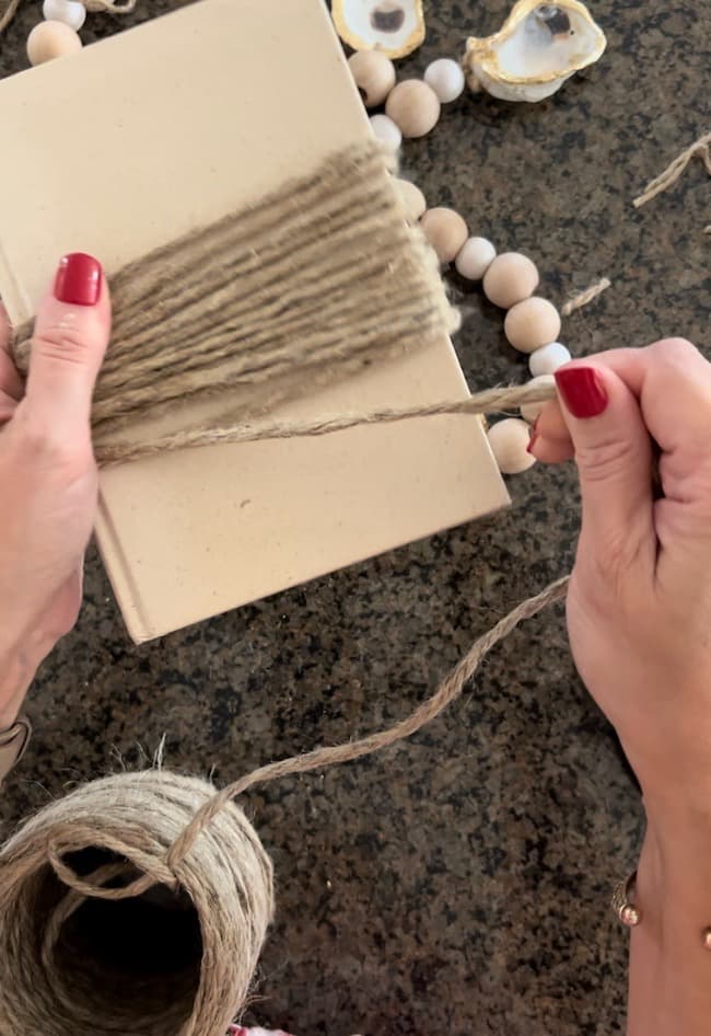 To create the tassel, start by wrapping the twine around a small book about 15 times.