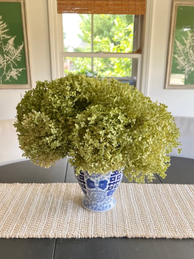 Breakfast room with dried hydrangeas and green and white botanical wall art