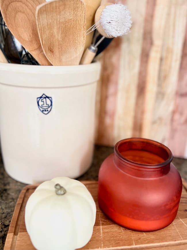 Warm wooden accents with cutting boards and wooden utensils in vintage crock.