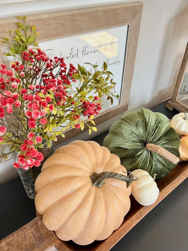 Pumpkin decor in a dough bowl on the dining room buffet - velvet pumpkins with red fall stems.