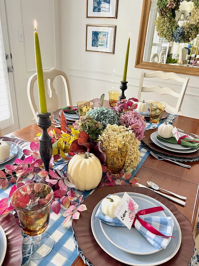 Dining room with table set for Thanksgiving in rich jewel tones