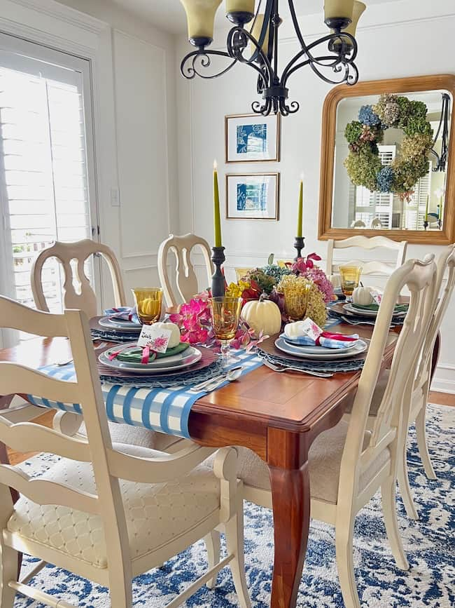 Thanksgiving Dinner Table centerpiece with dried hydrangeas, white pumpkins, fall stems, blue and white plaid paper table runner