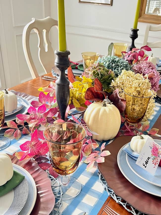 Thanksgiving Dinner Table centerpiece with dried hydrangeas, white pumpkins, fall stems, blue and white plaid paper table runner