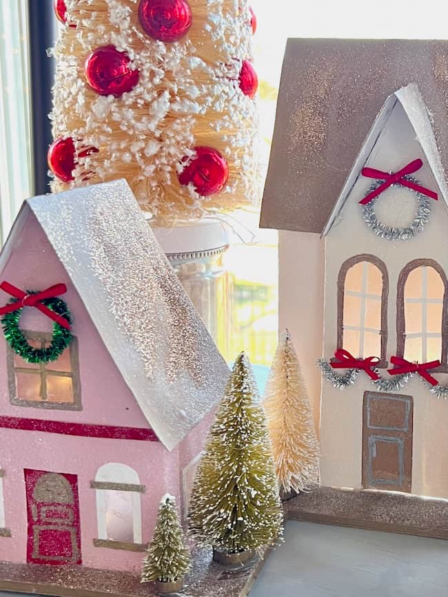 Handmade Paper Christmas Houses in pink, red, cream, and gold.