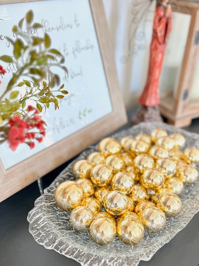 Vintage gold Christmas balls in glass bowl on buffet