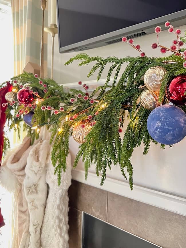 Christmas fireplace decor with Norfolk pine garland, and stockings