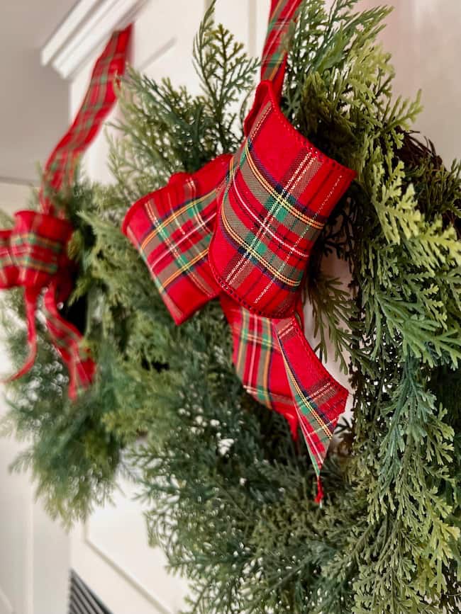 Christmas wreaths with Tartan plaid bows on kitchen cabinets