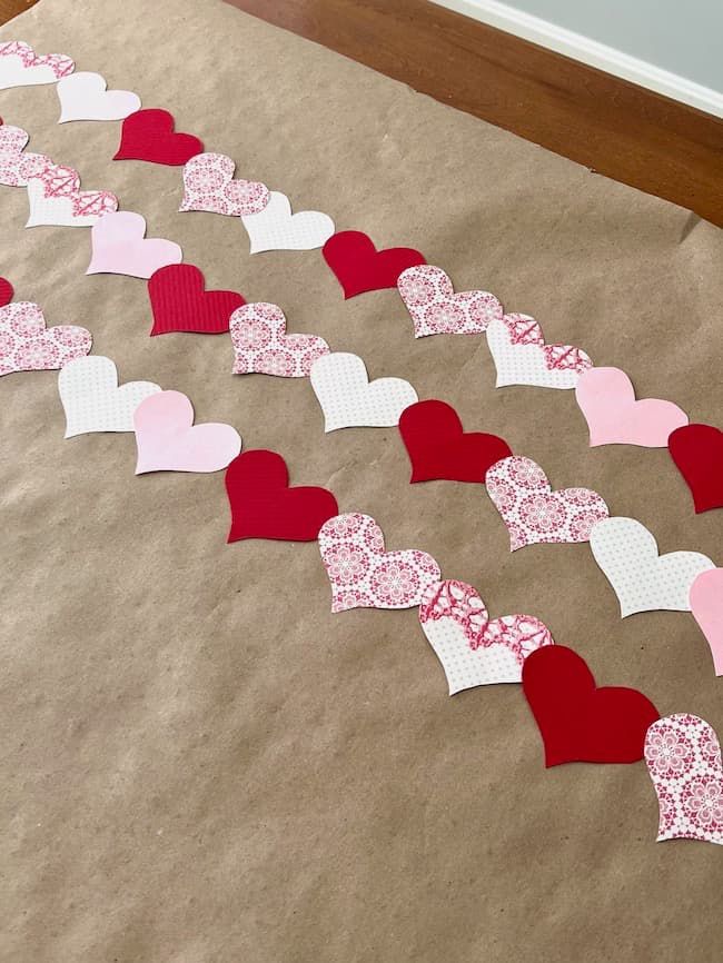 Lay out your pink and red paper hearts in the pattern you want for your garland.