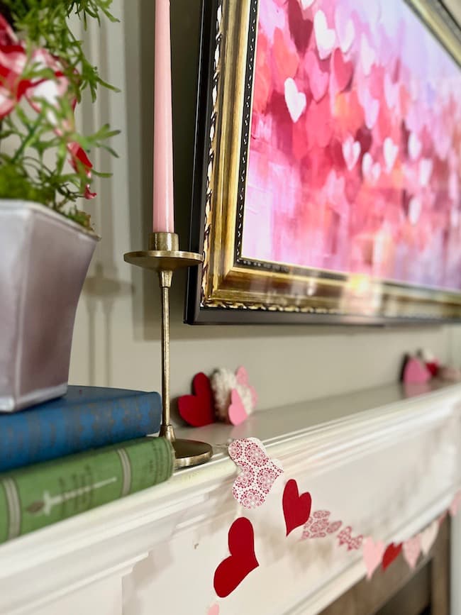 Valentine's Day garland and a heart topiary on mantel with Valentine heart digital art on the tv