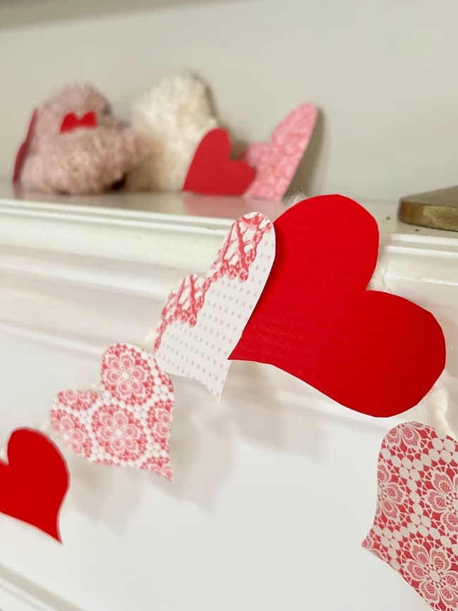 DIY Valentine's Day Garland made with paper hearts from pink and red patterned card stock paper.