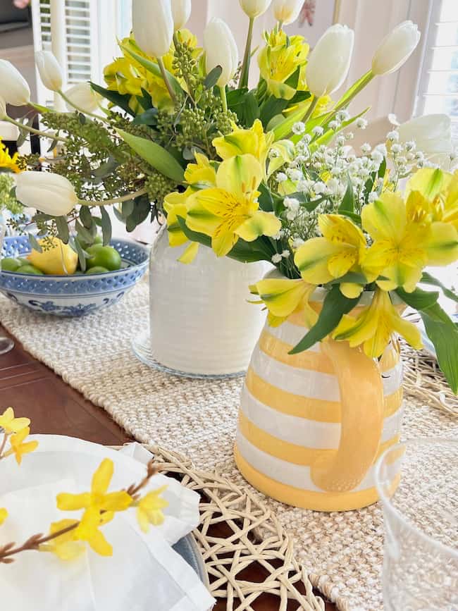 Yellow and White spring centerpieces in Yellow and white stripes pitcher.