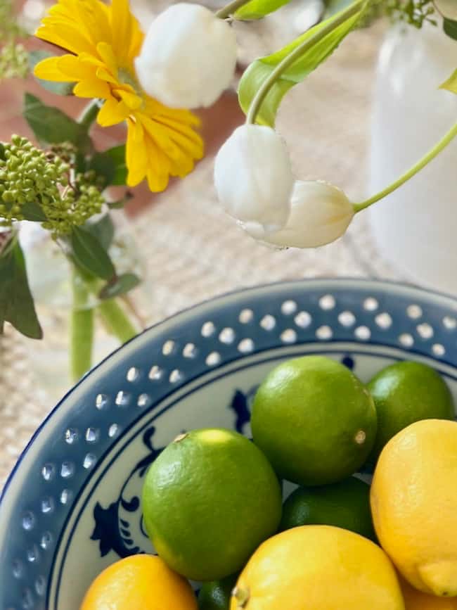 Blue and White Bowl full of lemons and limes on spring tablescape